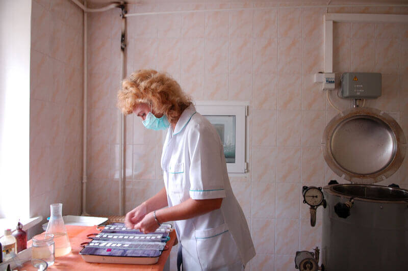 A laboratory worker wearing a surgical mask works with samples. (Photo: PATH/Mike Wang) 